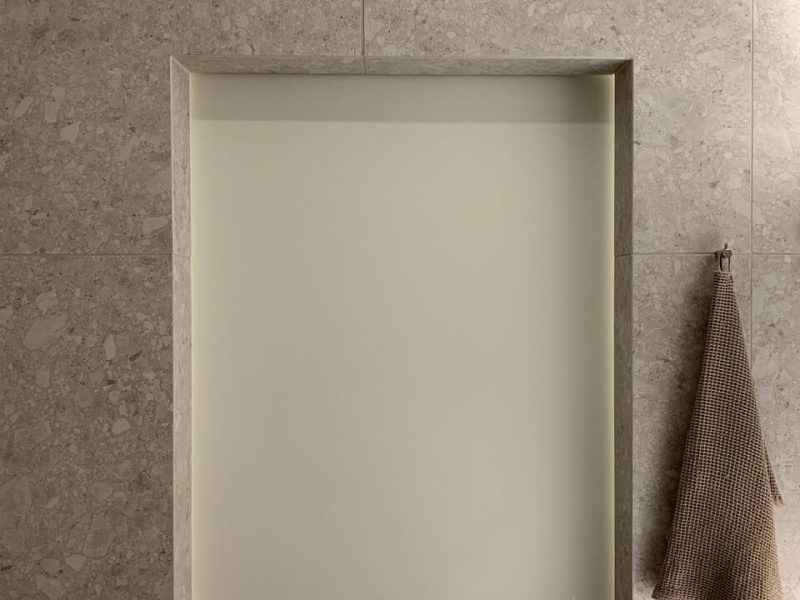 Valkoinen väliovi laatoitetun seinän vieressä